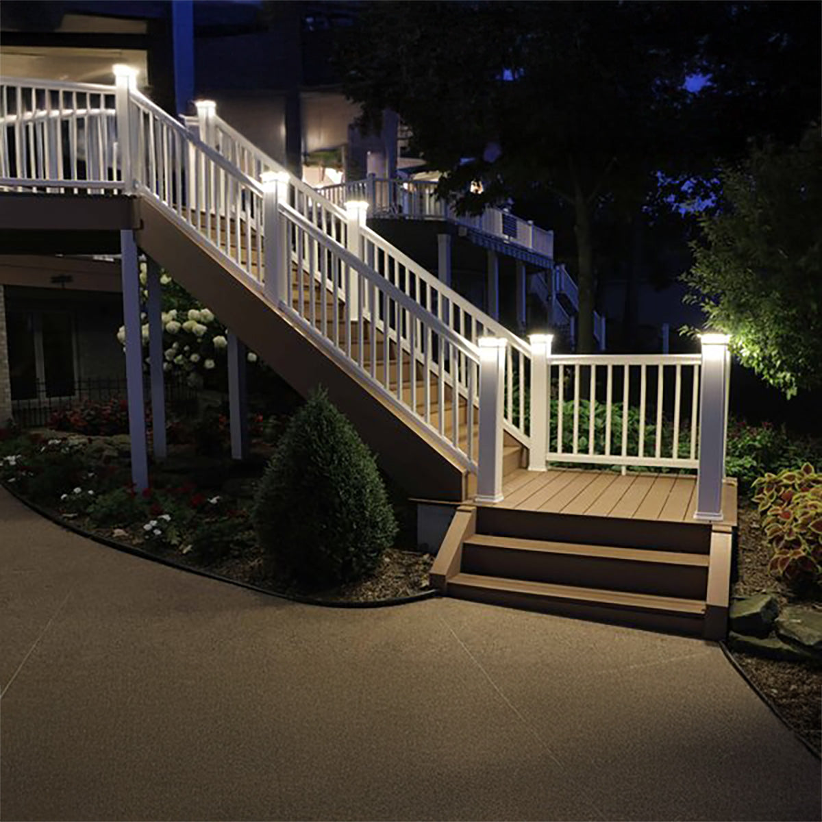 Outdoor staircase with white railings and lights at night