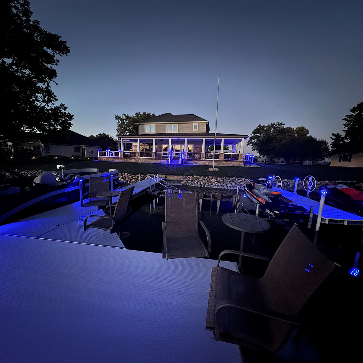 Boat dock at night with illuminated house in the background
