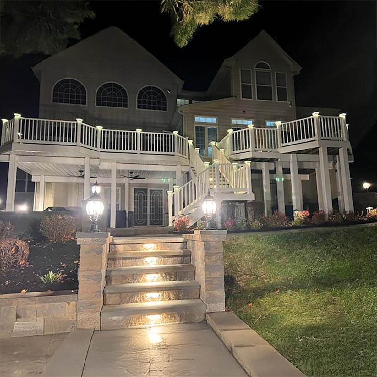 House exterior with lit steps and deck at night