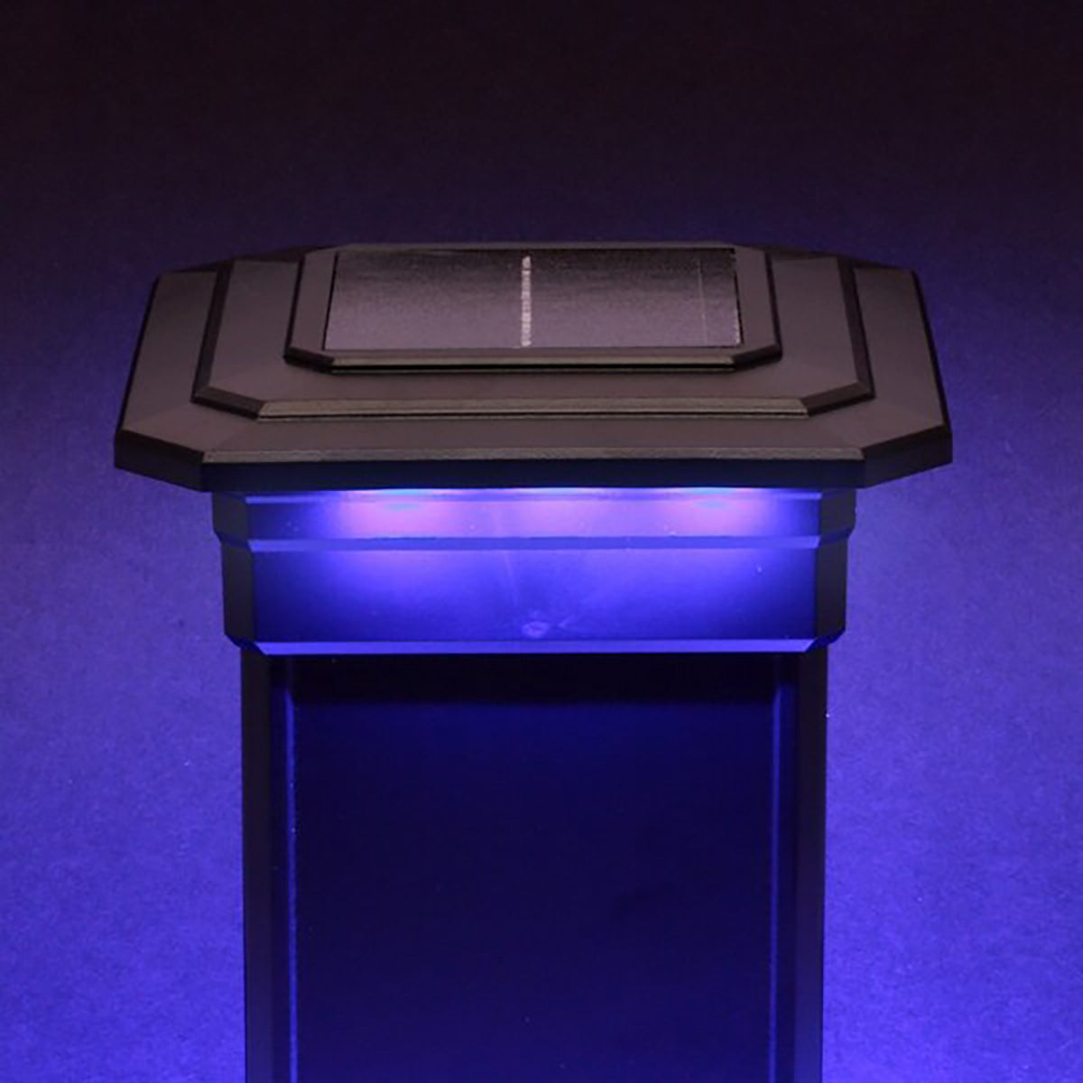 Solar-powered LED light post with blue glow on a dark background