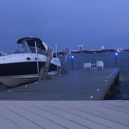 Boat docked at a pier with city skyline in the background during evening.