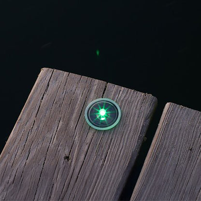Green LED light on a wooden surface with a dark background