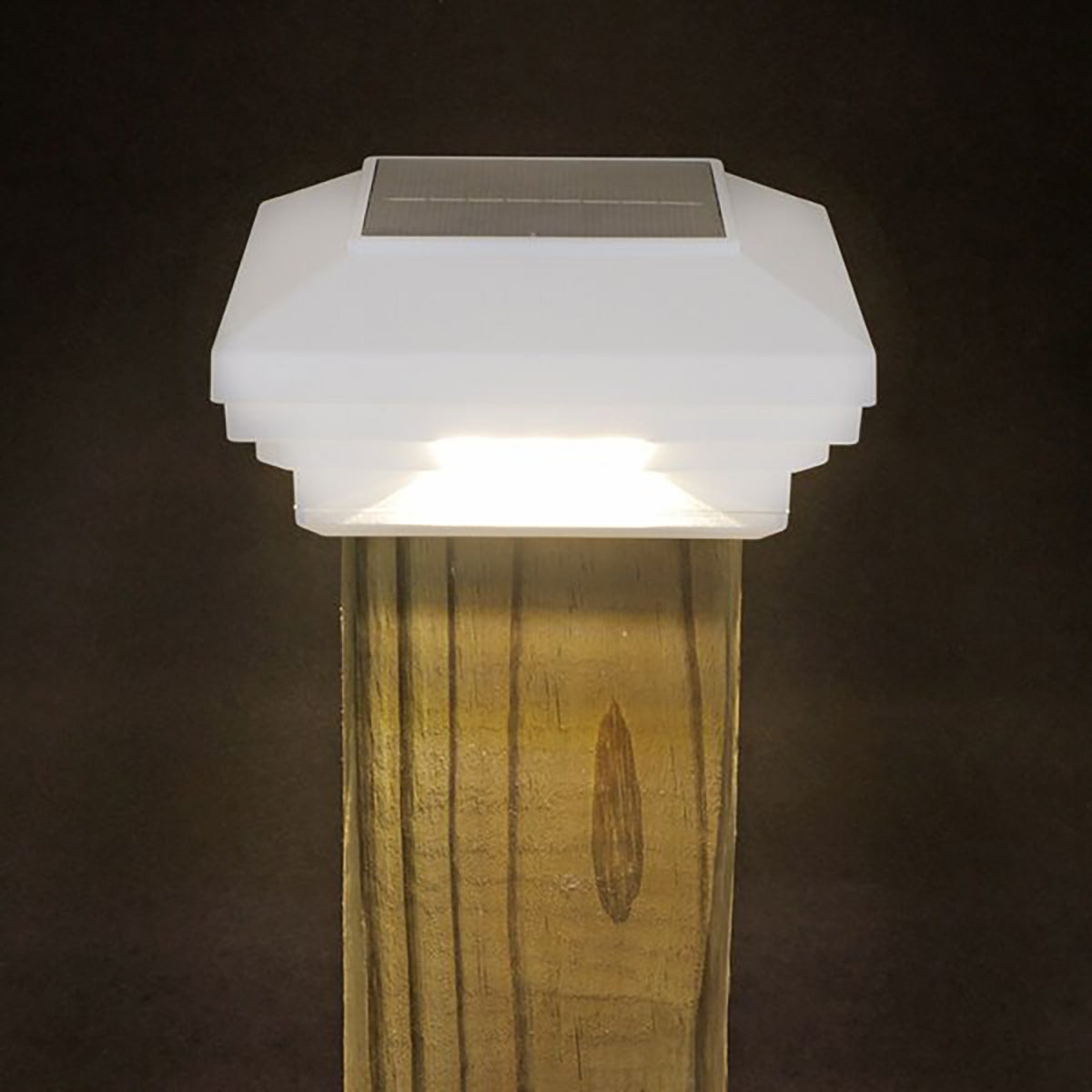 Solar-powered outdoor light fixture on a wooden post against a dark background