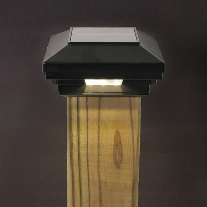Solar-powered outdoor light fixture on a wooden post against a dark background