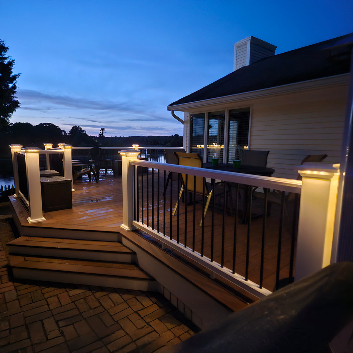 Evening view of a deck with outdoor furniture and lighting