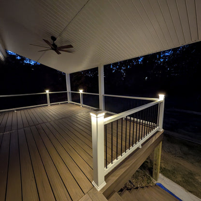 Wooden deck with railing and ceiling fan at night