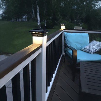 Outdoor deck with solar lights, cushioned chairs, and a view of grass and trees.
