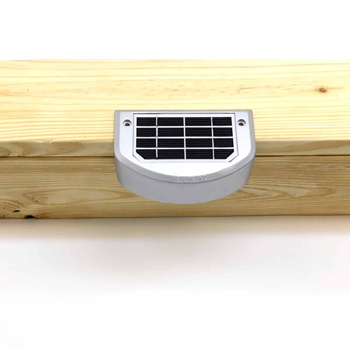 Solar panel attached to a wooden surface on a white background