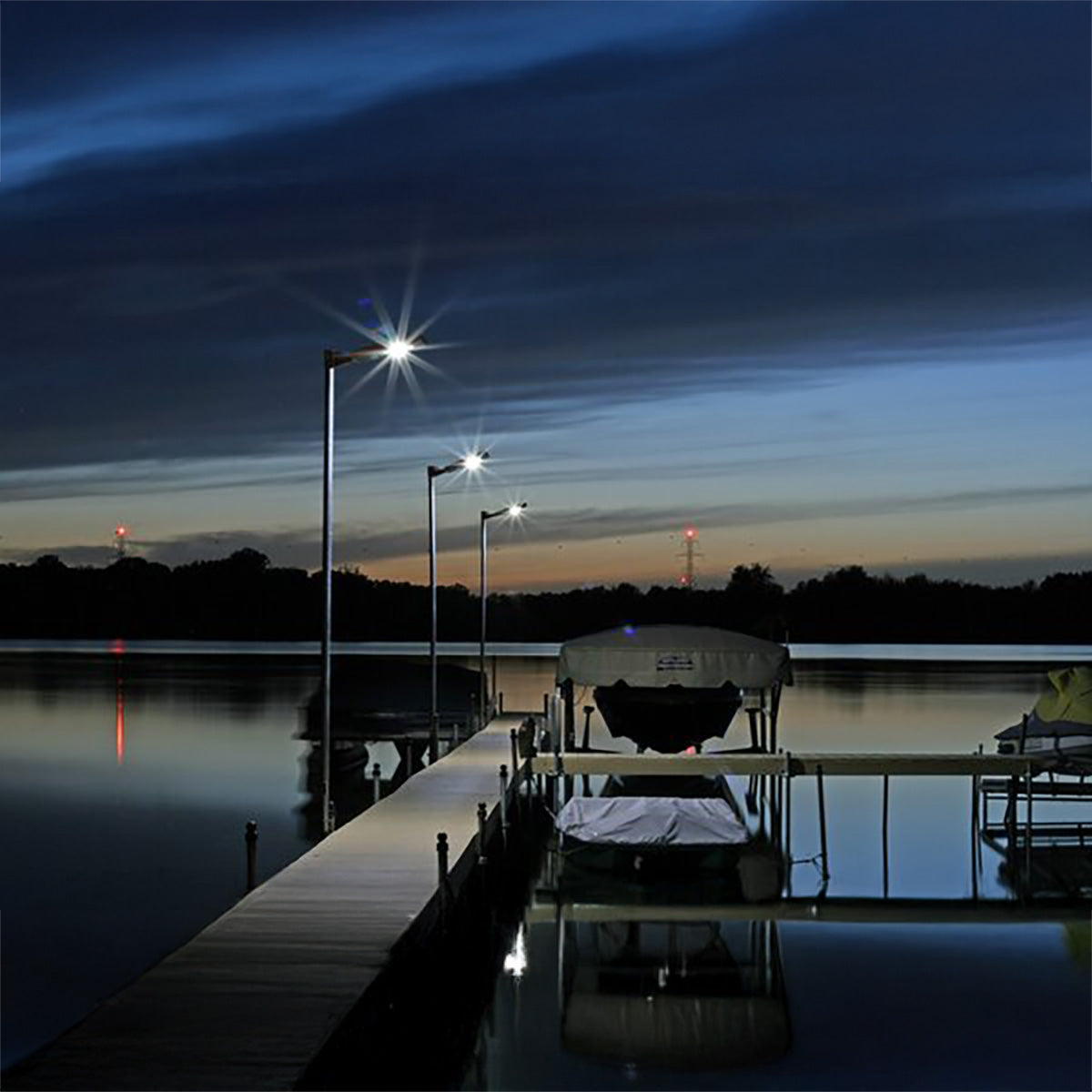 Dock with boats at night under illuminated streetlights
